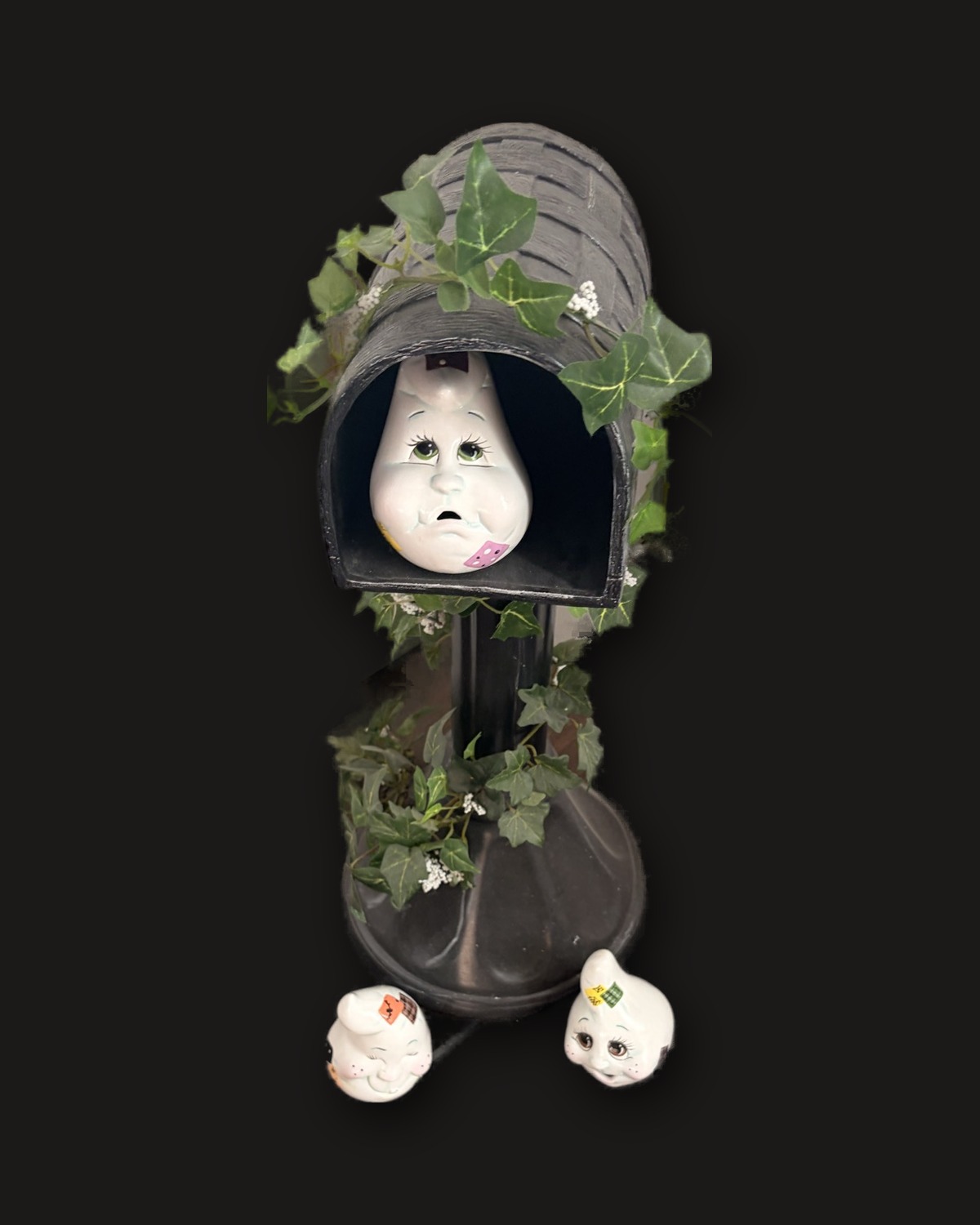 A finished ghost mailbox on black velvet: a ghost peeking out, ivy around the post, two small ghosts at its foot.