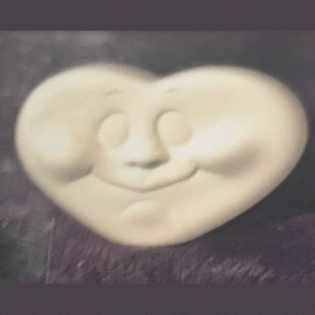 Heart face, number 63, unpainted bisque on black velvet